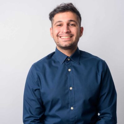 Studio shot of young handsome Iranian businessman against white background