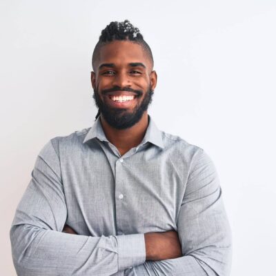 African american businessman with braids standing over isolated white background happy face smiling with crossed arms looking at the camera. Positive person.